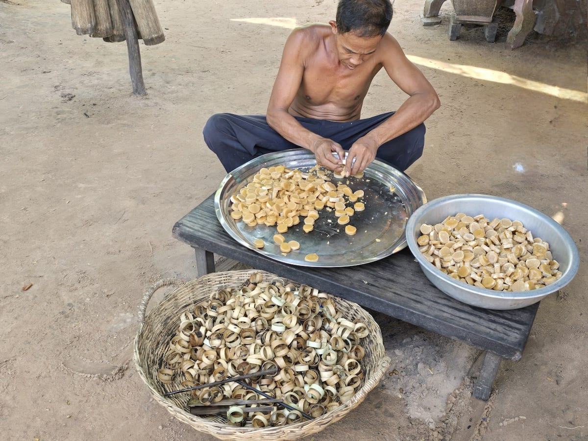 Mann in Kambodscha fertigt Snacks aus Klebreis. Foto: Beate Ziehres
