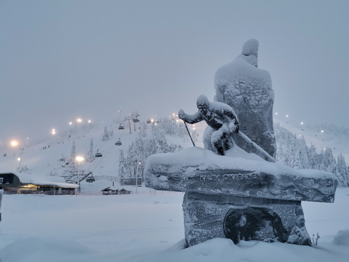 Kuusamo, Finnland: Beleuchtete Skipisten am Rukatunturi und Statue des in Kuusamo geborenen Skilangläufers Kalevi Oikarainen. Foto: Beate Ziehres, Reiselust-Mag