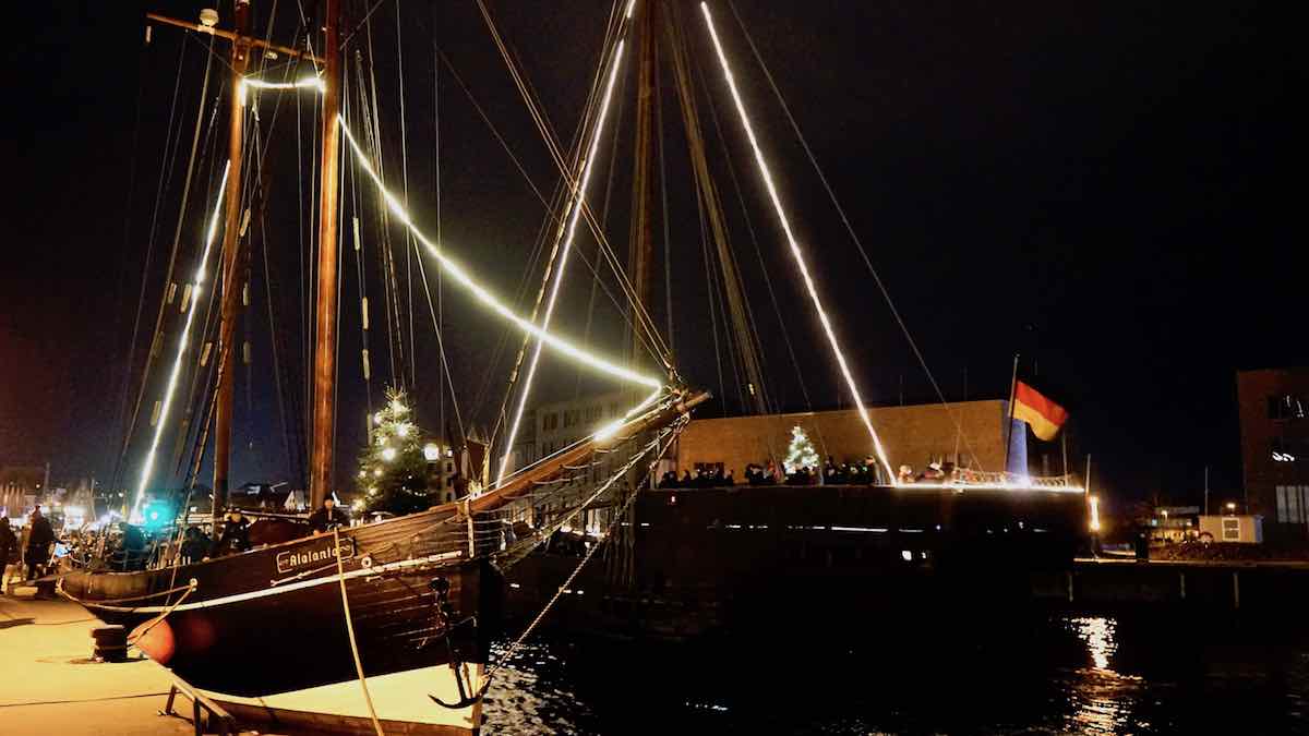 Lichterfahrt zur Seemannsweihnacht in Wismar: Die Kogge Wissemara passiert den Segler Atalanta – Foto: Beate Ziehres