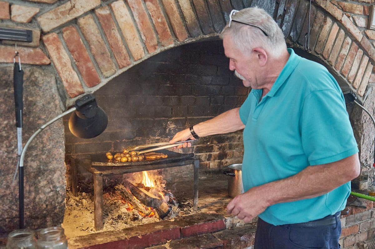 Piotr Michalski bereitet in der historischen Küche Linie w Ogniu Kartoffeln und Fleisch über dem offenen Feuer zu. Foto: Beate Ziehres, Reiselust-Mag